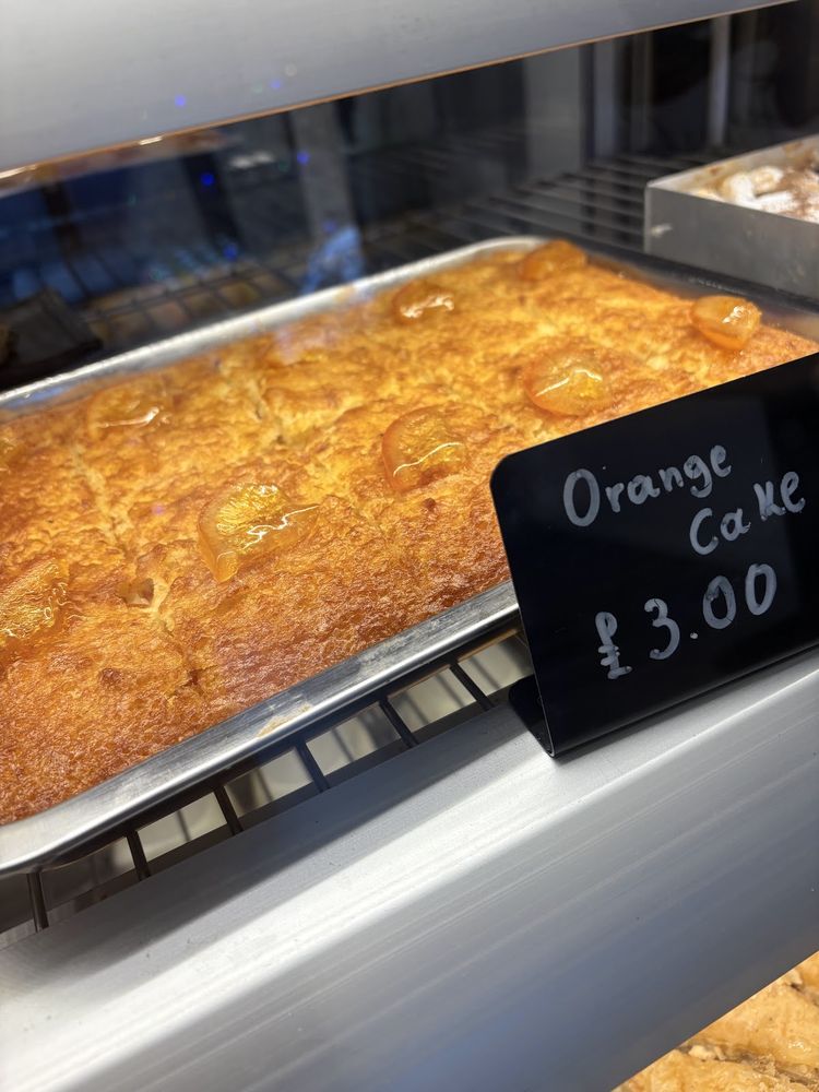 A whole golden orange cake in the lit display counter